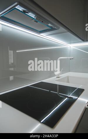 Moderne Küchenausstattung mit schwarzem Induktions- oder Elektroherd mit Cerankochfeld und weißer Arbeitsplatte Stockfoto