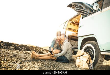 Hipster-Paar, das zusammen mit Oldtimer-Minivan-Transport unterwegs ist - Reise-Lifestyle-Konzept mit Indie-Leuten auf Minivan-Abenteuer-Reise Spaß haben Stockfoto