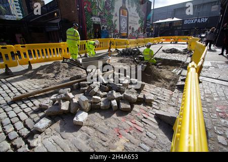 Ebor Street, Bauunternehmer, die Straßenbelag auf gesperrter Straße im Zentrum von Shoreditch in London ersetzen Stockfoto