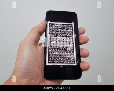 Seoul, Südkorea - 16 2021. Oktober: Ein Mann schaut sich die Koran-Bibel-App für muslime mit seinem Finger auf seinem iPhone an. Auf Wunsch der Chinesen gehen Stockfoto