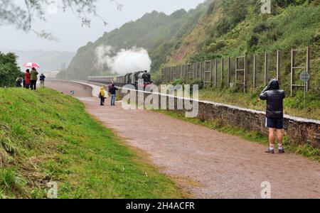 Dampfzug im Regen. Enthusiasten trotzen dem schlechten Wetter und beobachten die Mayflower-Bahntour am Sprey Point in Teignmouth, South Devon. Stockfoto