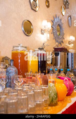 In der Nähe der Behälter mit Getränken befinden sich viele Gläser. Stockfoto