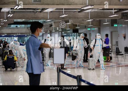 Samut Prakan, Thailand. November 2021. Reisende mit Schutzanzügen (PSA) gehen zum Kontrollpunkt am Flughafen Suvarnabhumi.Thailand öffnet das Land am 1. November für vollständig geimpfte Reisende aus Ländern mit geringem Risiko für eine Coronavirus-Pandemie, ohne Quarantäneanforderungen zu erfüllen. Dies soll die Tourismusindustrie und die Wirtschaft ankurbeln. Kredit: SOPA Images Limited/Alamy Live Nachrichten Stockfoto