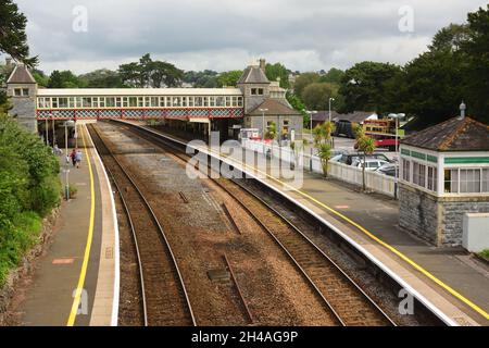 Bahnhof Torquay mit attraktiver Fußgängerbrücke und ehemaliger Signalbox auf dem Bahnsteig. Stockfoto