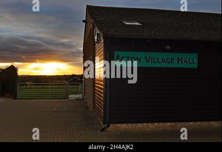 Als die Abenddämmerung am 22. Oktober 2021 fällt, leuchtet die untergehende Sonne die Holzseite des Dorfsaals bei Ecton in Northamptonshire auf. Stockfoto