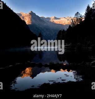 Spiegelung der Bergkette im See im Val di Mello in einem nebligen Morgen Stockfoto