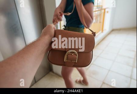 Dieb schnappt einer Frau in der Nähe des Aufzugs einen Beutel. Stockfoto