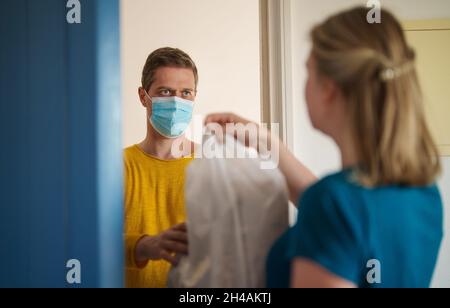 Maskierter Mann liefert während einer Pandemie Nahrung. Stockfoto