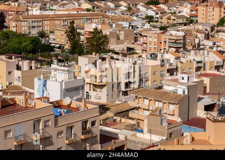 Blick über die Stadt Puerto de Mazarron, Murcia, Spanien, mit Dächern, einem Sonnenbaden auf einem Balkon und einer hängenden Wäsche für Frauen Stockfoto