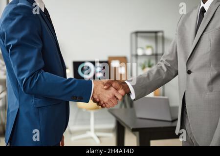 Seitenansicht von zwei Geschäftsleuten, die nach einem erfolgreichen Deal im Büro die Hände schütteln, Platz kopieren Stockfoto