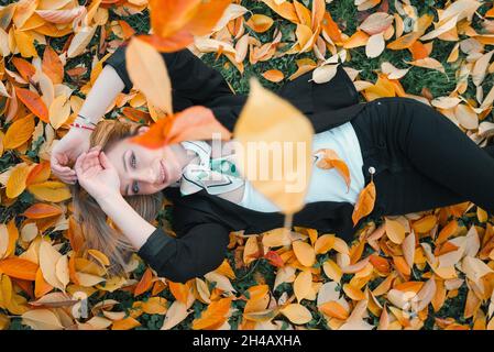 Schöne junge Frau im Herbst geht nach draußen Stockfoto