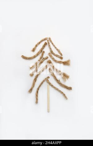 Weihnachtsbaum aus Seil, Jute, Garn und Holzmatch auf weißem Hintergrund. Bio DIY Öko Handwerk Weihnachtsbaum. Kreativer Kunsturlaub. Einfaches Weihnachtsfest Stockfoto