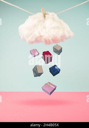 Geschenkschachteln, die von einer Wolke auf einem Seil fallen. Valentinstag, Weihnachten oder Silvester-Idee. Minimaler abstrakter Winterurlaub und Shopping-Konzept. Speicherplatz kopieren. Stockfoto