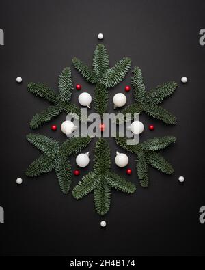 Konzeptionelle Weihnachtskarte mit dekorativer Schneeflocke auf schwarzem Hintergrund Stockfoto