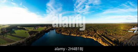 Panoramablick auf einen ruhigen See mit dichtem Wald und bebauten Feldern Stockfoto