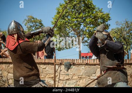 Mittelalterliche maurische Reenaktoren, die Schwertkämpfe durchführen. Almossasa Kulturfestival von Badajoz, Spanien Stockfoto