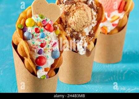 Nahaufnahme von Seifenblasenwaffeleis in Papierverpackungen auf blauem Hintergrund Stockfoto