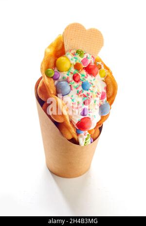 Eiscreme mit Seifenwaffeln und bunten Süßigkeiten auf weißem Hintergrund Stockfoto