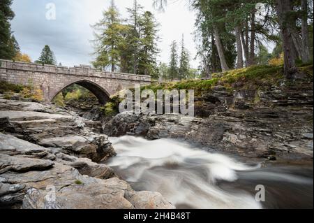 Die Steinbrücke, die über die Stromschnellen des Flusses Dee in den Cairngorms Mountains in Schottland führt Stockfoto