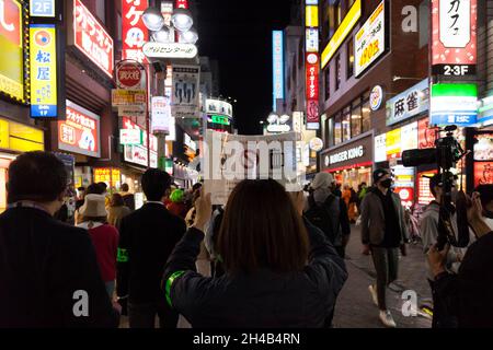 Tokio, Japan. Oktober 2021. Eine lokale Regierungsstreife hält ein Schild, das die Menschen warnt, während der Halloween-Feiern in Shibuya keinen Alkohol zu trinken.Tokyos Gouverneur der Shibuya-Abteilung forderte Halloween-Feiernden auf, sich in diesem Jahr wieder von seinem berühmten Gerangel fernzuhalten, um die Ausbreitung von Coronavirus-Infektionen einzudämmen. Polizei und private Sicherheitskräfte werden in der Gegend patrouillieren, um Massenprobleme zu vermeiden und Alkoholverkäufe in lokalen Geschäften und Bars wurden abgeraten. Kredit: SOPA Images Limited/Alamy Live Nachrichten Stockfoto