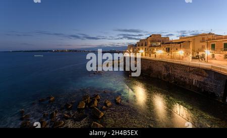 Sonnenuntergang an der Küste von Ortigia, einem Reiseziel und einer antiken griechischen Stadt in Syrakus, Sizilien, Italien, mit der alten mittelalterlichen Stadt und dem Mediterr Stockfoto