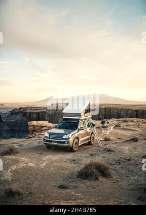 4x4 Fahrzeug mit Dachzelt Camping in der Wüste bei Sonnenuntergang Stockfoto