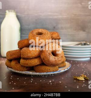 Gewürzte Donuts mit Milch und Tellern Stockfoto