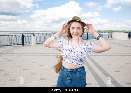 Rotschopf Hipster Teenager-Mädchen mit langen roten Haaren zu Fuß in der Sommerstadt Stockfoto