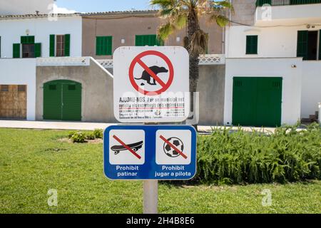 Mallorca, Spanien, 27. Juli 2021: Ein Schild, das vor Hunden warnt, die auf dem Rasen Fouling haben, und darauf hinweist, dass keine Skateboarding- oder Fußballspiele auf der schönen Insel gemacht wurden Stockfoto