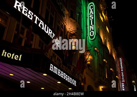 Prag, CZ - 28. oktober 2021: Prager Nachtleben Postkarte Neon Schild Casino und Restaurant auf einer altmodischen Gebäudewand mit großen Laternen. Redaktionell Stockfoto