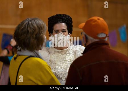 Die Künstlerin Emily McLaughlin spricht am Sonntag, den 31. Oktober 2021, mit Besuchern auf der Dia de los Muertos Community-Messe in Tieton, Washington. Tieton Stockfoto