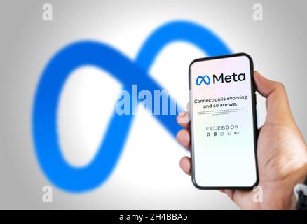 Menlo Park, CA, USA, Oktober 28 2021: Hand hält ein Telefon mit der Meta Mobile App auf dem Bildschirm und das Logo im Hintergrund verschwommen. Meta ist a te Stockfoto