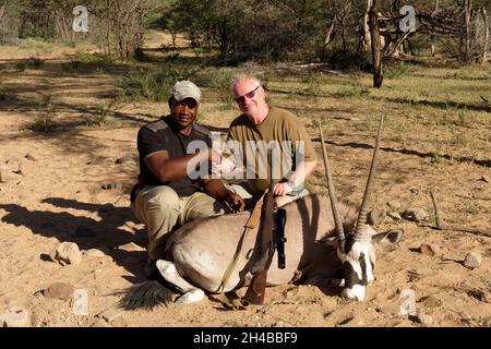 Farm Ozondjisse: Jäger und Jagdmeister mit Oryx-Antilope (Oryx gazella), Omaruru District, Erongo Region, Namibia Stockfoto