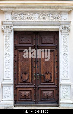 SINAIA, RUMÄNIEN - 27. Sep 2021: Eine alte geschnitzte Holztür auf Schloss Peles in der Stadt Sinaia - Rumänien Stockfoto