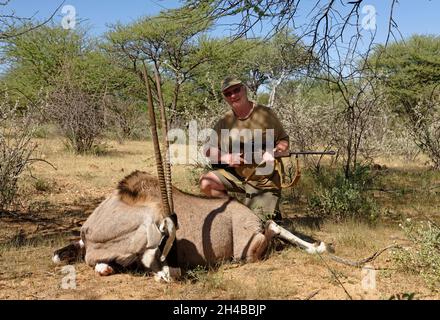 Farm Ozondjisse: Jäger mit Oryx-Antilope (Oryx gazella), Omaruru District, Erongo Region, Namibia Stockfoto