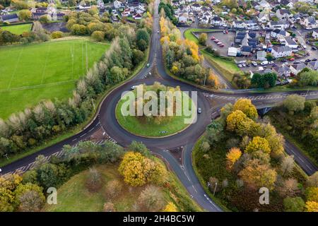 Luftdrohnenaufnahme eines kleinen Verkehrskreisel in einer walisischen Stadt im Herbst Stockfoto