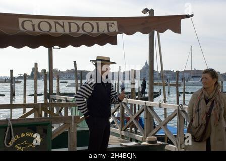 VENEDIG, ITALIEN - 13. Oktober 2013: Alleinerziehende männliche Gondoliere an seinem Stand auf dem Canal Grande von Venedig, Italien Stockfoto