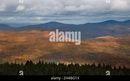 Fantastische Draufsicht auf die Herbstlandschaft. Berge mit bunten Bäumen, blauer Himmel mit Wolken. Stockfoto