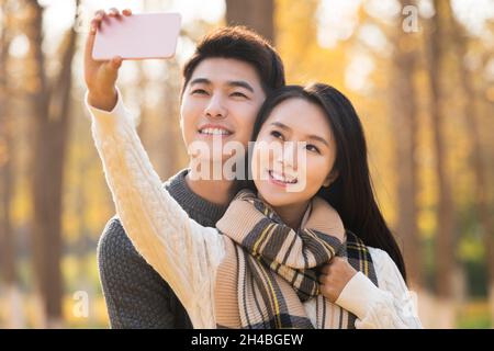 Glückliches junges Paar, das Selfies mit ihrem Mobiltelefon macht Stockfoto