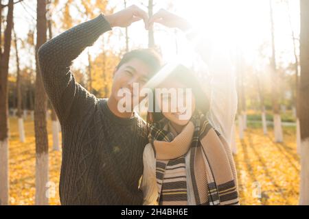 Glückliche junge Liebhaber machen Herzensgeste Stockfoto