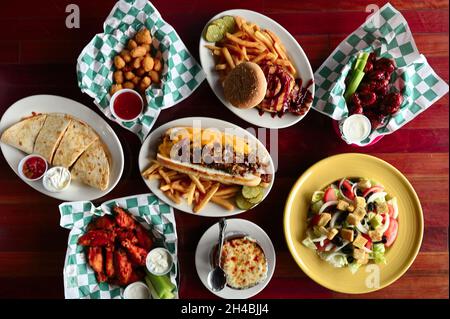 Food Story, American Pub Fare Philly Cheesesteak, Buffalo Wings und Cheeseburger mit Blick von oben Stockfoto