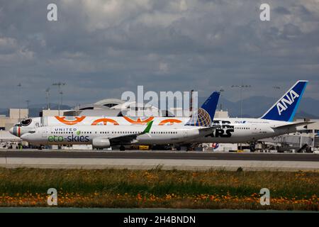 Los Angeles, Kalifornien, USA. März 2019. Eine United Airlines Boeing Co. 737-900 (Registration N75432) mit United Eco-Skies Lacktaxis vorbei an einer All Nippon Airways (ANA) Boeing Co. 777-300ER mit Star Wars BB-8 Lackierung (Registration JA789A) am Donnerstag, den 28. März 2019 in Los Angeles, Kalifornien. © 2019 Patrick T. Fallon (Bild: © Patrick Fallon/ZUMA Press Wire) Stockfoto