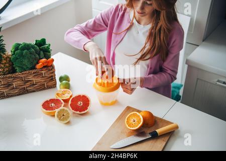 Rote Haare Frau Herstellung von Zitrusfrüchten Saft für einen gesunden Lebensstil Design. Gesunde Ernährung. Fruchtsaft. Stockfoto