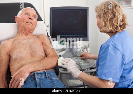 Arzt, der einen Patienten im Krankenhaus mit Ultraschalluntersuchung untersucht Stockfoto