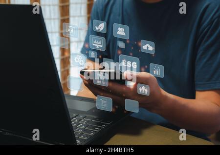 Nachhaltiges Geschäftskonzept (Environmental, Social, Governance: ESP).Hand halten Telefon-Symbol Business virtuell auf dem Bildschirm Hintergrund. Stockfoto