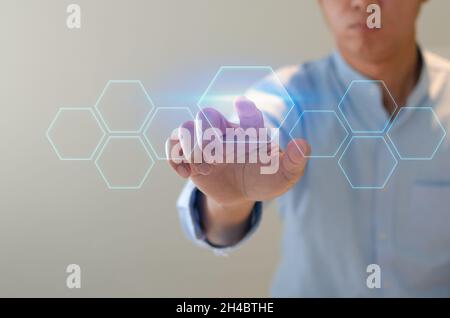 Der Mensch verweist auf eine futuristische Schnittstelle. Auf einem virtuellen Bildschirm drückt ein Geschäftsmann eine Taste. Konzept für ein Unternehmen Es gibt Platz für Text. Stockfoto