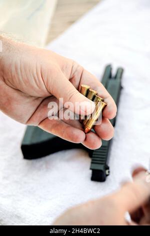 Menschliche Hand mit einer halbautomatischen Seitenarm im Hintergrund Stockfoto