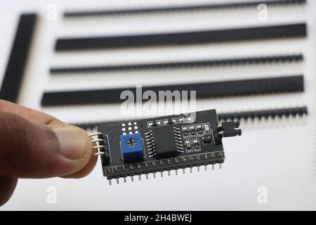 I2C-Treibermodul zur Schnittstelle mit LCD-Modul in der Hand gehalten mit Stiftleiste auf einem Hintergrund zeigt elektronische Projekte Konzept Stockfoto