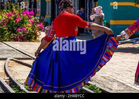 Eine ältere Frau, die in einem langen ethnischen Kleid tanzt Stockfoto