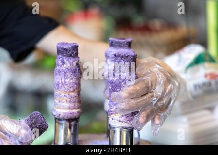 Menschen, die die philippinische Wüste Puto Bumbong gemacht haben Stockfoto